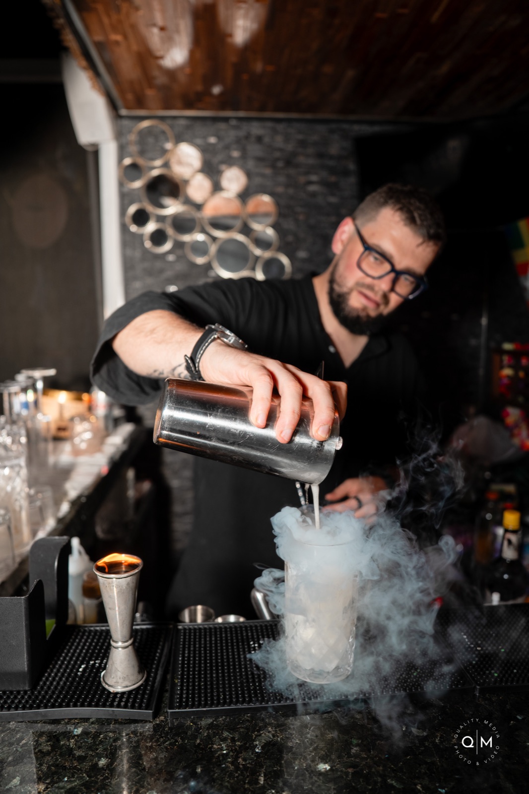 Dry ice smoke cascading over a craft cocktail
