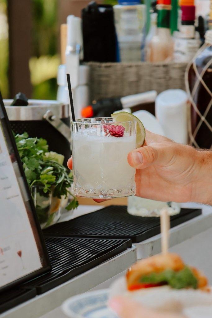 Margarita with lime and edible flower garnish at a Miami garden party