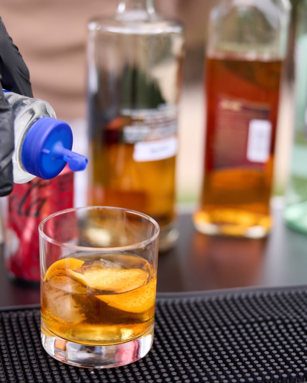 Old Fashioned cocktail being poured over a large ice cube